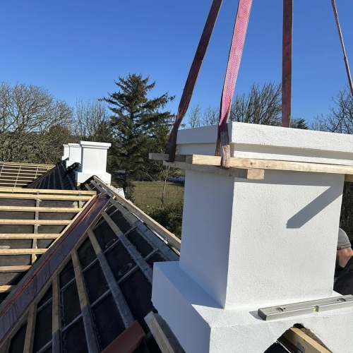 Krankørsel med montering af hvid skorsten på taget.