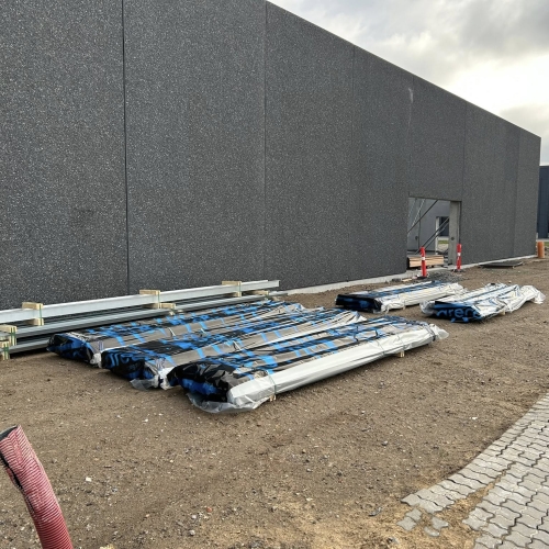 Krankørsel med byggematerialer lagt ved facade i Hjørring.