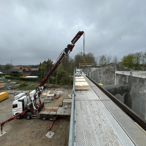 Krankørsel med løft af byggematerialer til taget på byggeplads.