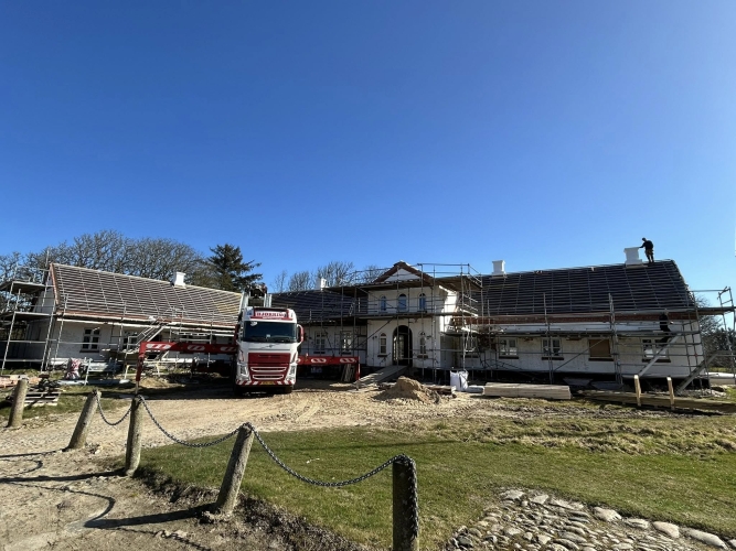 Krankørsel foran bygning med flere skorstene monteret.