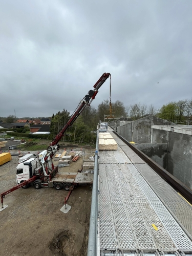 Krankørsel med løft af byggematerialer til taget på byggeplads.