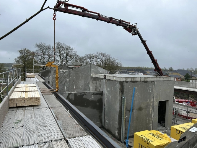 Krankørsel med gul løfteanordning over betonkonstruktion