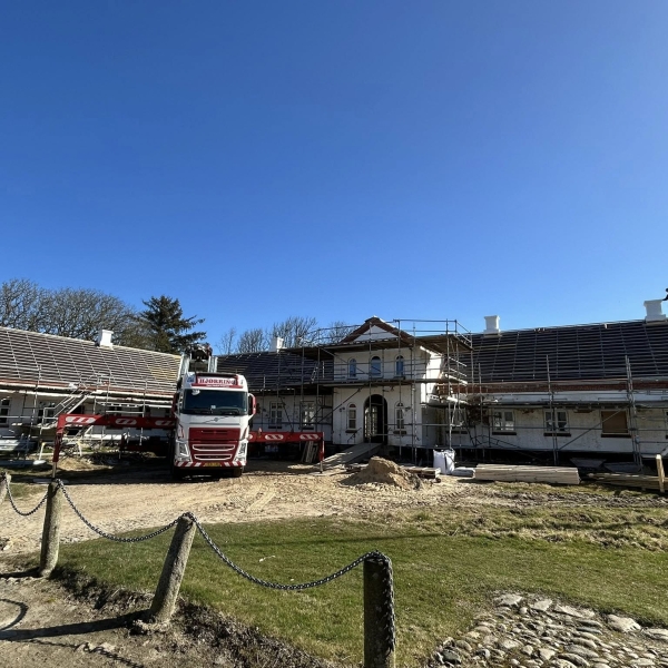 Krankørsel foran bygning med flere skorstene monteret.