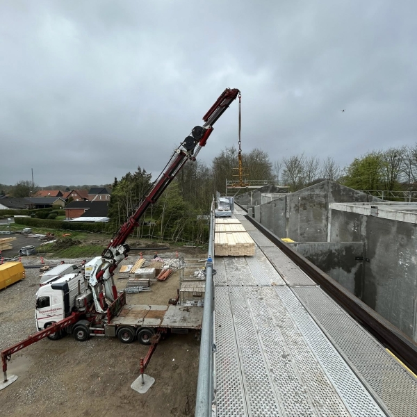 Krankørsel med løft af byggematerialer til taget på byggeplads.