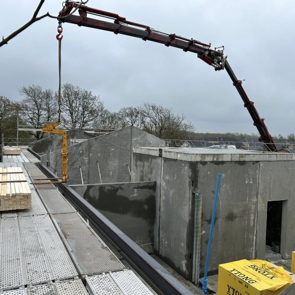Krankørsel med gul løfteanordning over betonkonstruktion