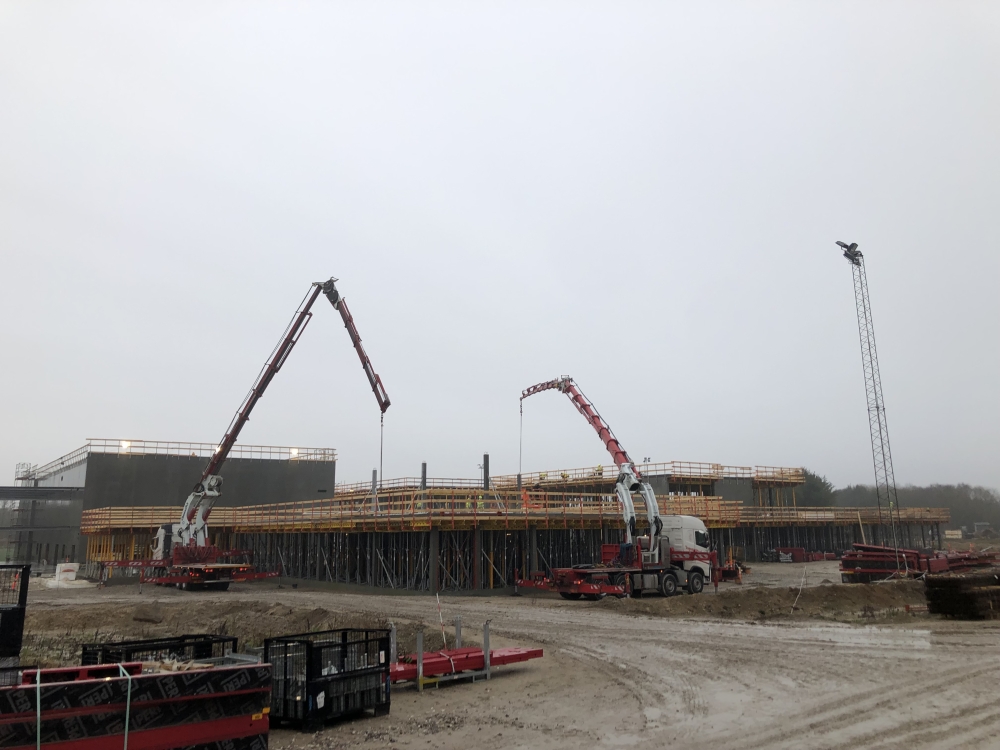 Krankørsel på stor byggeplads med to mobilkraner.